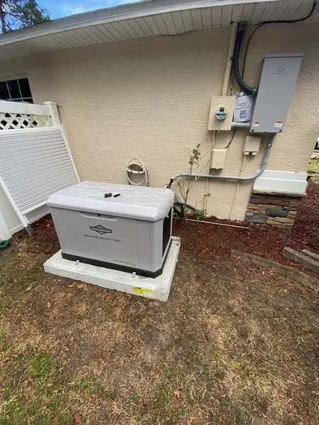 Standby generator with its transfer switch on the home's exterior wall